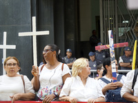 People hold crosses during a demonstration in downtown Sao Paulo, Brazil, on December 9, 2024, to protest against police violence following...