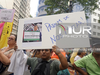 People hold crosses during a demonstration in downtown Sao Paulo, Brazil, on December 9, 2024, to protest against police violence following...