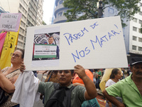 People hold crosses during a demonstration in downtown Sao Paulo, Brazil, on December 9, 2024, to protest against police violence following...