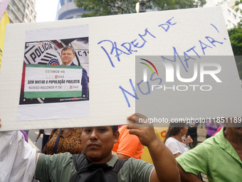 People hold crosses during a demonstration in downtown Sao Paulo, Brazil, on December 9, 2024, to protest against police violence following...