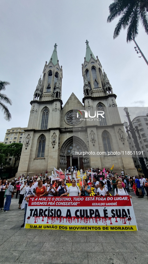 People hold crosses during a demonstration in downtown Sao Paulo, Brazil, on December 9, 2024, to protest against police violence following...