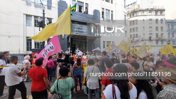 People hold crosses during a demonstration in downtown Sao Paulo, Brazil, on December 9, 2024, to protest against police violence following...