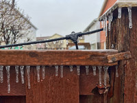 Icicles hang from a wooden fence as freezing rain coats surfaces with a sheet of ice in Toronto, Ontario, Canada, on December 9, 2024. (