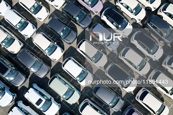 An aerial view shows various types of cars waiting to be loaded at a railway freight yard in Hangzhou, China, on December 9, 2024. 