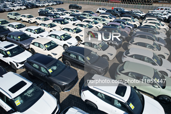 An aerial view shows various types of cars waiting to be loaded at a railway freight yard in Hangzhou, China, on December 9, 2024. 