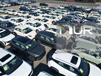 An aerial view shows various types of cars waiting to be loaded at a railway freight yard in Hangzhou, China, on December 9, 2024. (