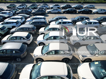 An aerial view shows various types of cars waiting to be loaded at a railway freight yard in Hangzhou, China, on December 9, 2024. (