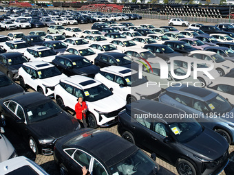 An aerial view shows various types of cars waiting to be loaded at a railway freight yard in Hangzhou, China, on December 9, 2024. (