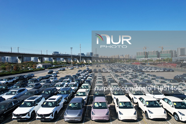 An aerial view shows various types of cars waiting to be loaded at a railway freight yard in Hangzhou, China, on December 9, 2024. 