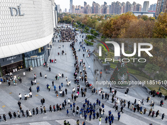 Customers line up in front of a Pangdonglai (DL) store in Xuchang, China, on December 7, 2024. (