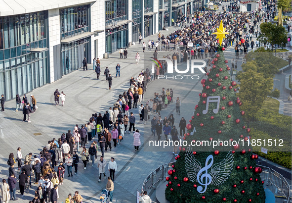 Customers line up in front of a Pangdonglai (DL) store in Xuchang, China, on December 7, 2024. 