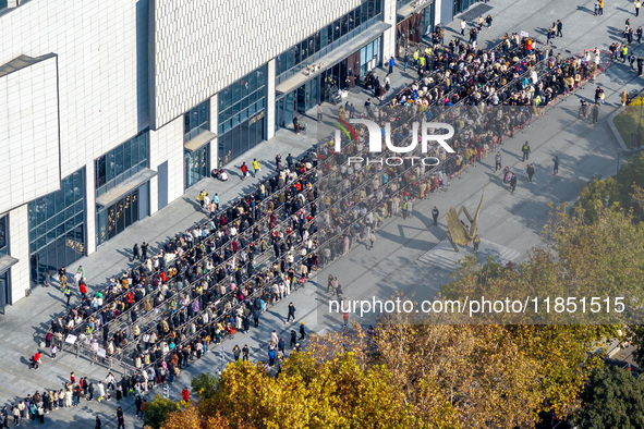 Customers line up in front of a Pangdonglai (DL) store in Xuchang, China, on December 7, 2024. 