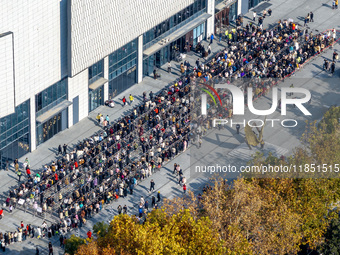 Customers line up in front of a Pangdonglai (DL) store in Xuchang, China, on December 7, 2024. (