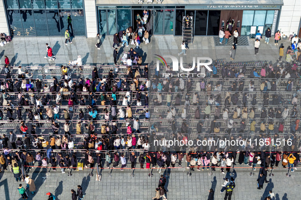 Customers line up in front of a Pangdonglai (DL) store in Xuchang, China, on December 7, 2024. 