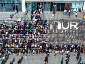 Customers line up in front of a Pangdonglai (DL) store in Xuchang, China, on December 7, 2024. (