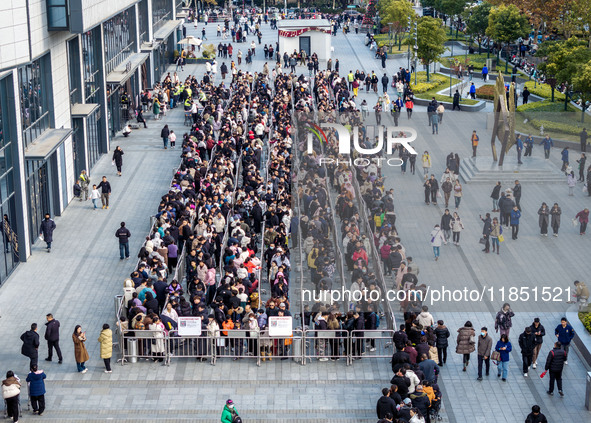 Customers line up in front of a Pangdonglai (DL) store in Xuchang, China, on December 7, 2024. 