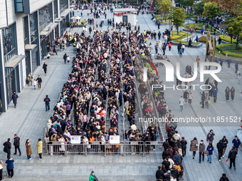 Customers line up in front of a Pangdonglai (DL) store in Xuchang, China, on December 7, 2024. (