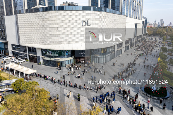 Customers line up in front of a Pangdonglai (DL) store in Xuchang, China, on December 7, 2024. 