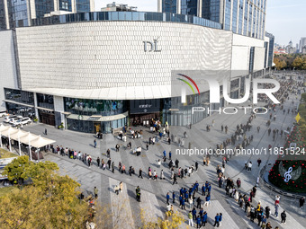 Customers line up in front of a Pangdonglai (DL) store in Xuchang, China, on December 7, 2024. (