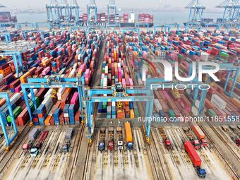 Vehicles transport foreign trade containers at a fully automated terminal in Qingdao Port in Qingdao, China, on December 10, 2024. (