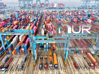 Vehicles transport foreign trade containers at a fully automated terminal in Qingdao Port in Qingdao, China, on December 10, 2024. (