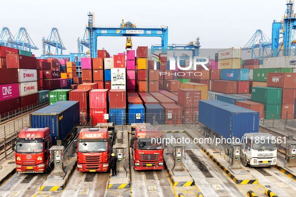 Vehicles transport foreign trade containers at a fully automated terminal in Qingdao Port in Qingdao, China, on December 10, 2024. 