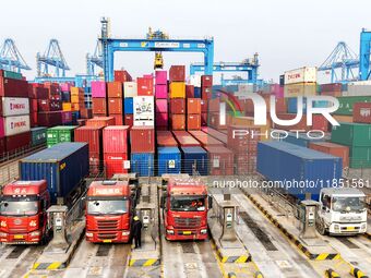 Vehicles transport foreign trade containers at a fully automated terminal in Qingdao Port in Qingdao, China, on December 10, 2024. (