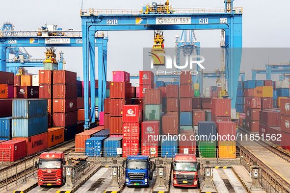 Vehicles transport foreign trade containers at a fully automated terminal in Qingdao Port in Qingdao, China, on December 10, 2024. 