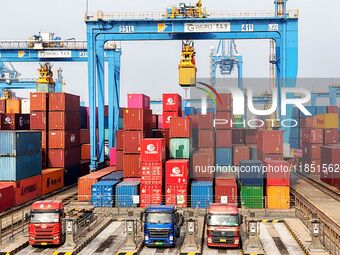 Vehicles transport foreign trade containers at a fully automated terminal in Qingdao Port in Qingdao, China, on December 10, 2024. (