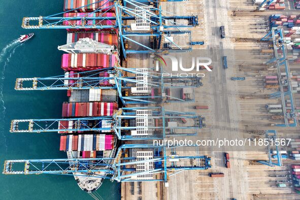 Cargo ships load and unload foreign trade containers at a fully automated terminal in Qingdao Port in Qingdao, China, on December 10, 2024. 