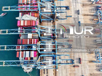 Cargo ships load and unload foreign trade containers at a fully automated terminal in Qingdao Port in Qingdao, China, on December 10, 2024....