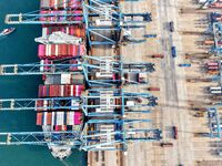 Cargo ships load and unload foreign trade containers at a fully automated terminal in Qingdao Port in Qingdao, China, on December 10, 2024....