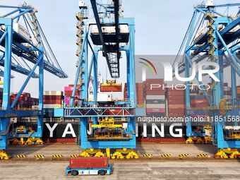 Cargo ships load and unload foreign trade containers at a fully automated terminal in Qingdao Port in Qingdao, China, on December 10, 2024....