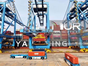 Cargo ships load and unload foreign trade containers at a fully automated terminal in Qingdao Port in Qingdao, China, on December 10, 2024....