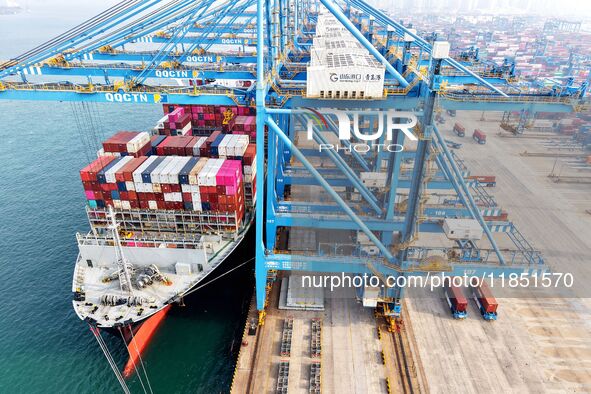 Cargo ships load and unload foreign trade containers at a fully automated terminal in Qingdao Port in Qingdao, China, on December 10, 2024. 