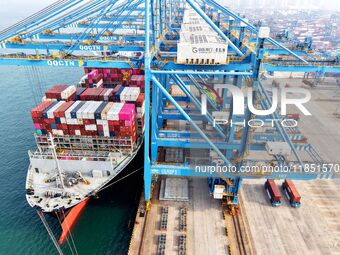 Cargo ships load and unload foreign trade containers at a fully automated terminal in Qingdao Port in Qingdao, China, on December 10, 2024....