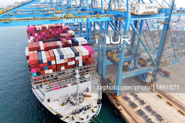 Cargo ships load and unload foreign trade containers at a fully automated terminal in Qingdao Port in Qingdao, China, on December 10, 2024. 