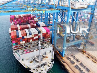 Cargo ships load and unload foreign trade containers at a fully automated terminal in Qingdao Port in Qingdao, China, on December 10, 2024....