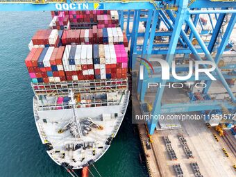 Cargo ships load and unload foreign trade containers at a fully automated terminal in Qingdao Port in Qingdao, China, on December 10, 2024....