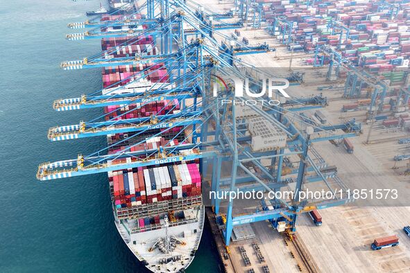 Cargo ships load and unload foreign trade containers at a fully automated terminal in Qingdao Port in Qingdao, China, on December 10, 2024. 