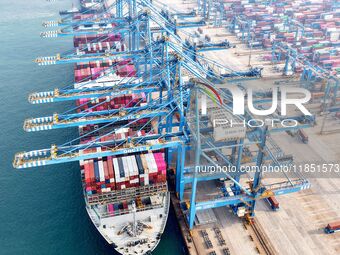 Cargo ships load and unload foreign trade containers at a fully automated terminal in Qingdao Port in Qingdao, China, on December 10, 2024....