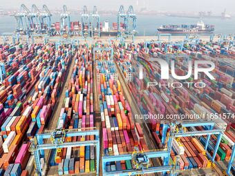 Cargo ships load and unload foreign trade containers at a fully automated terminal in Qingdao Port in Qingdao, China, on December 10, 2024....