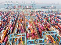 Cargo ships load and unload foreign trade containers at a fully automated terminal in Qingdao Port in Qingdao, China, on December 10, 2024....