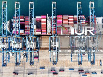 Cargo ships load and unload foreign trade containers at a fully automated terminal in Qingdao Port in Qingdao, China, on December 10, 2024....