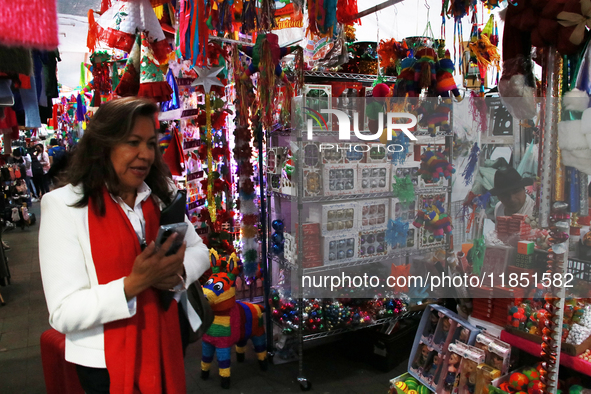 A woman walks past a stand where various items are sold for the Christmas season in the Tlalpan Center in Mexico City, Mexico, on December 7...