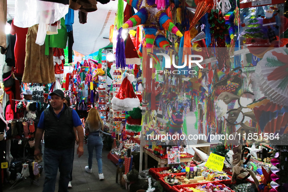 A man walks through a market where various items are sold for the Christmas season and the posadas, installed in the Tlalpan Center in Mexic...