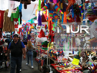 A man walks through a market where various items are sold for the Christmas season and the posadas, installed in the Tlalpan Center in Mexic...