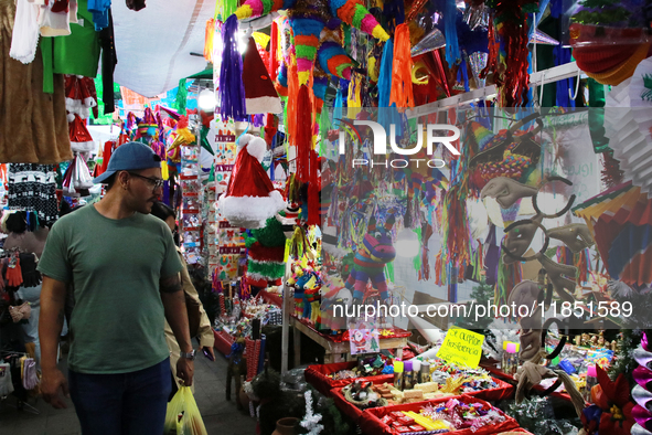 A man walks through a market where various items are sold for the Christmas season and the posadas, installed in the Tlalpan Center in Mexic...