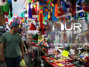 A man walks through a market where various items are sold for the Christmas season and the posadas, installed in the Tlalpan Center in Mexic...