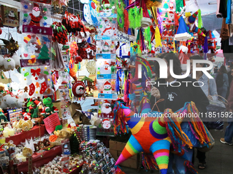 A woman carries a pinata through a market where different items are sold for the Christmas and Posadas season in the Tlalpan Center in Mexic...